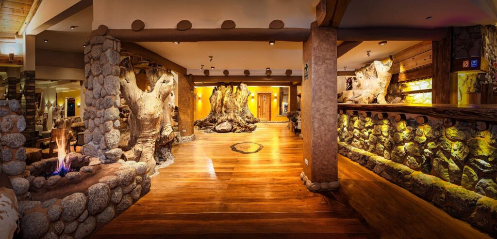 Rustic and warm interior of a wellness retreat featuring natural wood and stone elements with a central fireplace