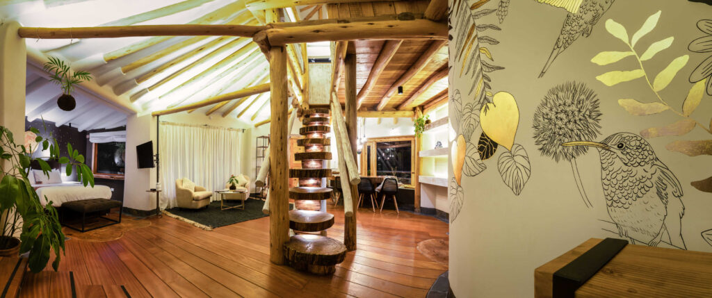 Spacious interior of a retreat showcasing a spiral wooden staircase, cozy seating areas, and nature-inspired wall art