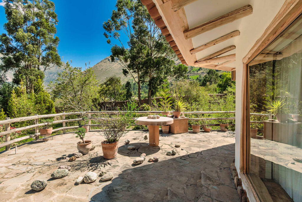 Sunny terrace with potted plants and a panoramic view of the mountains at a serene retreat location in the Sacred Valley Peru