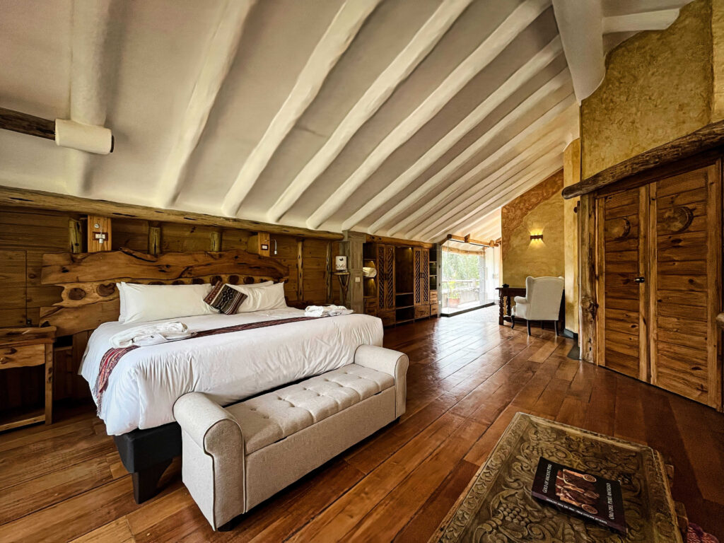 Spacious and elegantly furnished luxury suite with rustic wooden decor and warm natural lighting, inviting a peaceful retreat