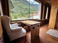 A cozy wooden desk space with a scenic mountain view, ideal for reflection or creative work in a serene retreat setting.