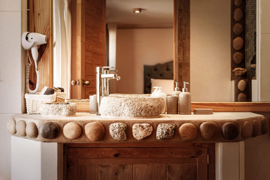 a rustic-styled bathroom with a stone basin and wooden accents, exuding a warm and natural feel.