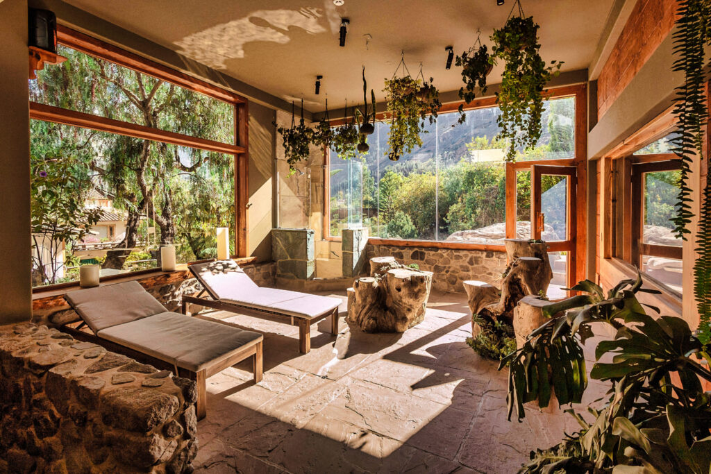 68. a tranquil spa interior with large windows offering a view of nature, lounge chairs for relaxation, and plants that add a touch of greenery, creating a serene and inviting atmosphere