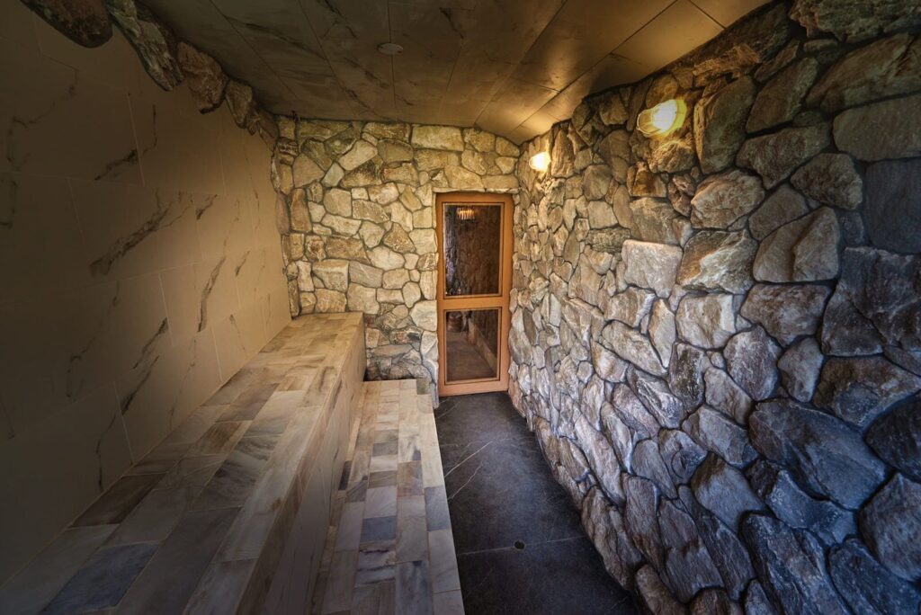 72. a spa steam room with a marble bench and natural stone walls, blending rustic charm with modern luxury.